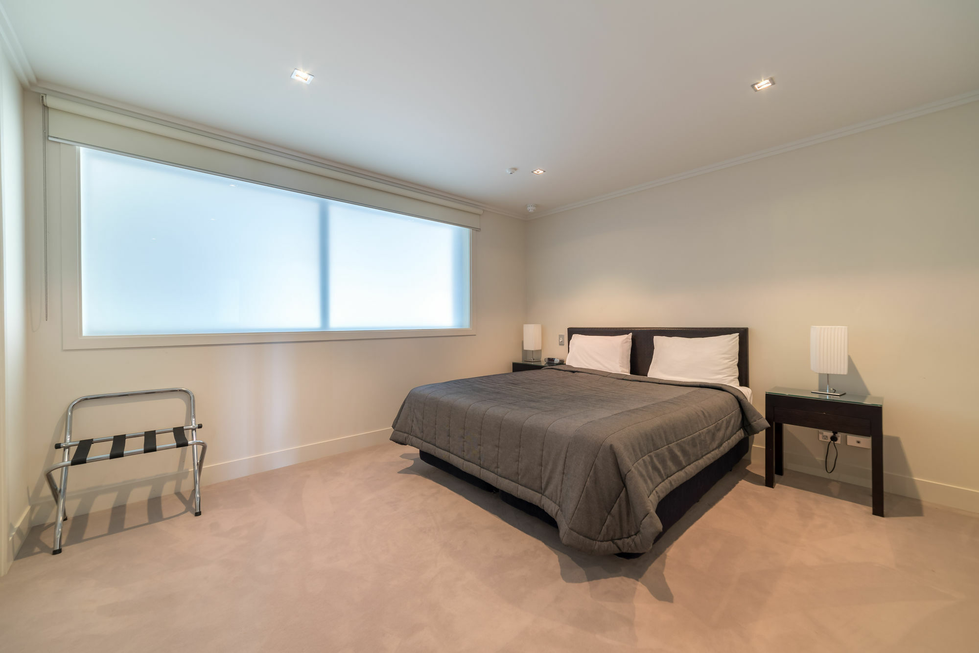 Sacred Waters Taupo Aparthotel Exteriör bild A bedroom with a bed, a chair and a bedside table